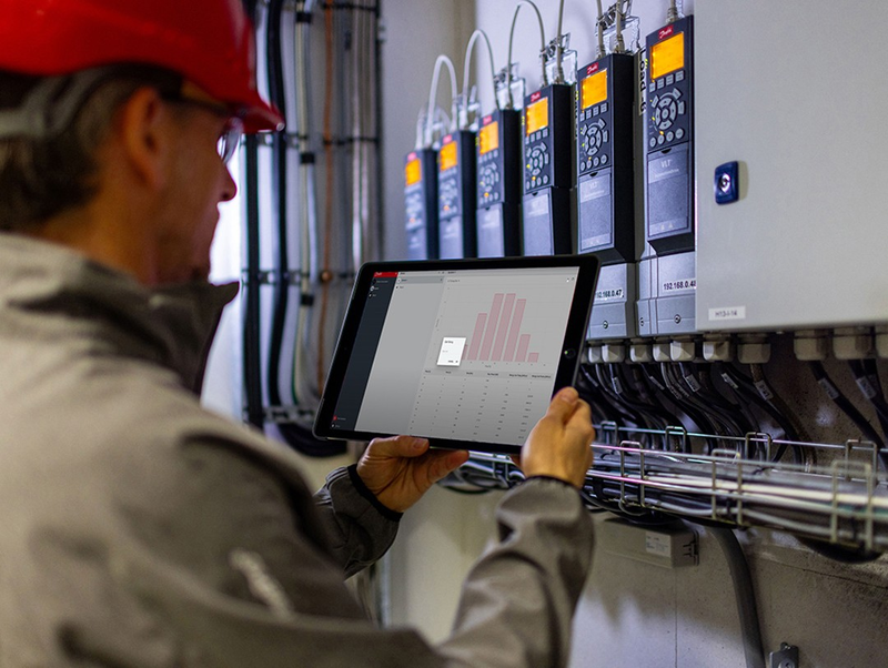 Engineer using a tablet to review drive diagnostics on installed Danfoss VLT drives