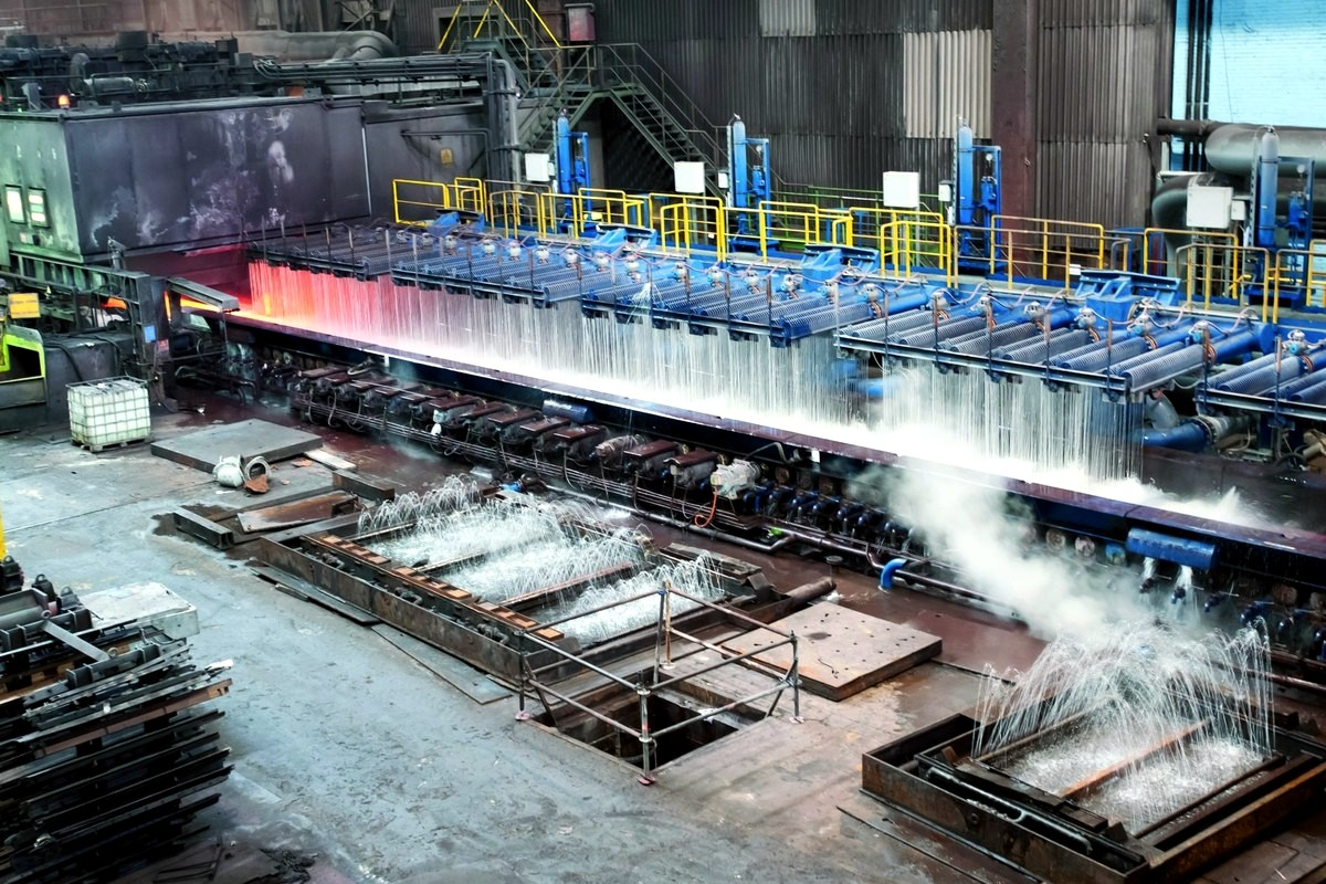 Hot steel strip passing through laminar cooling water jets